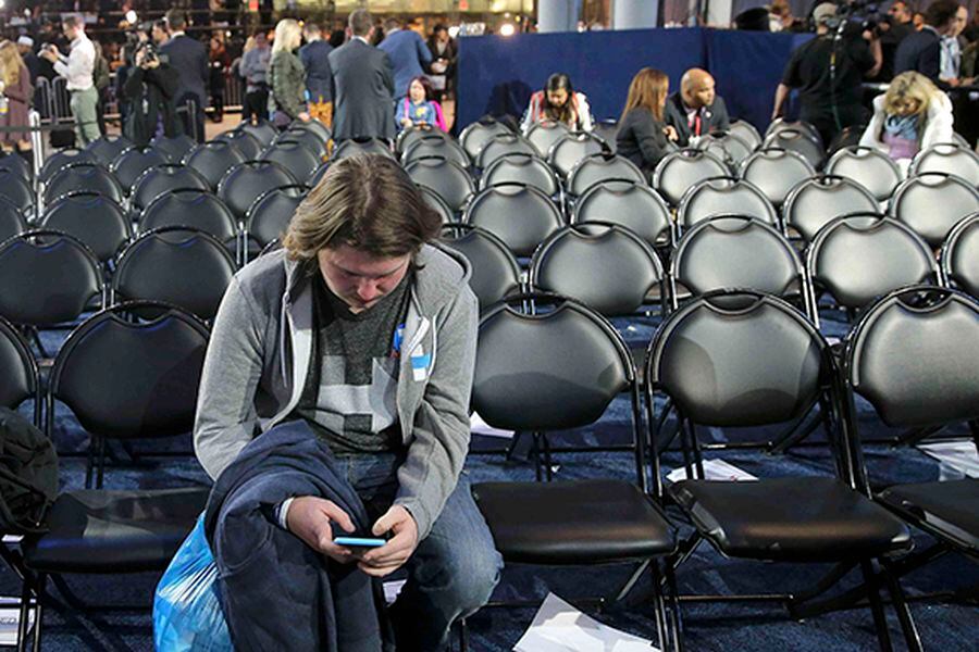 Supporter uses his smartphone as others leave Clinton rally in New York