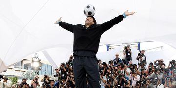 FILE PHOTO: Former soccer star Maradona balances a ball on his head during a photocall at the 61st Cannes Film Festival