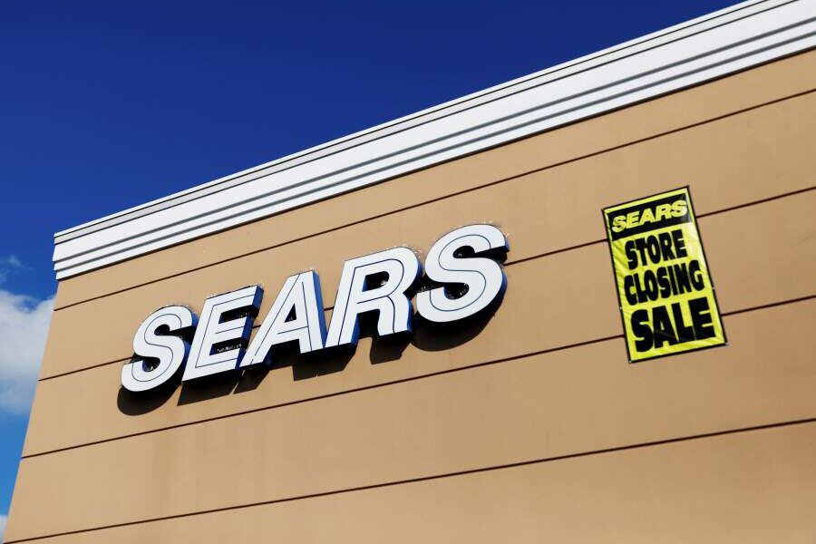 FILE PHOTO: A store closing sale sign is posted next to a Sears logo in New Hyde Park, New York