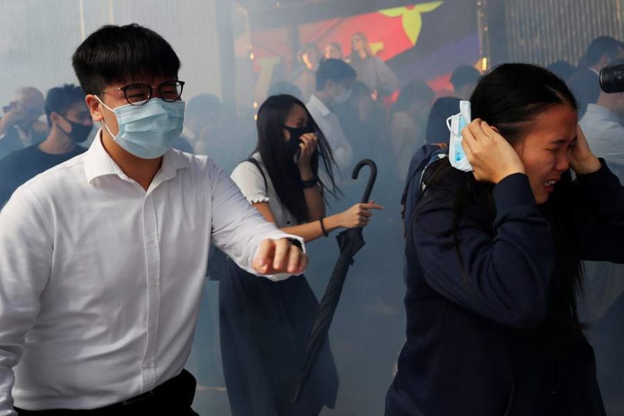 Office workers run away from tear gas as they attend a flash mob anti-government protest at the financial Central district in Hong Kong