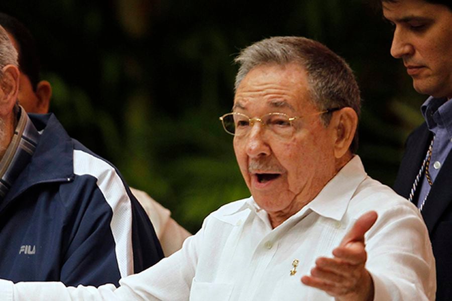 Cuba's President Raul Castro reacts next to his brother and former President Fidel Castro during closing ceremony of Cuban communist congress in Havana