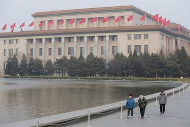 People walk near the Great Hall of the People, the venue of the upcoming NPC and CPPCC, in Beijing
