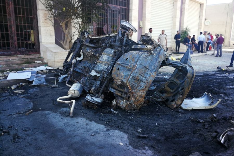 People gather at the site where a car bomb exploded in Benghazi