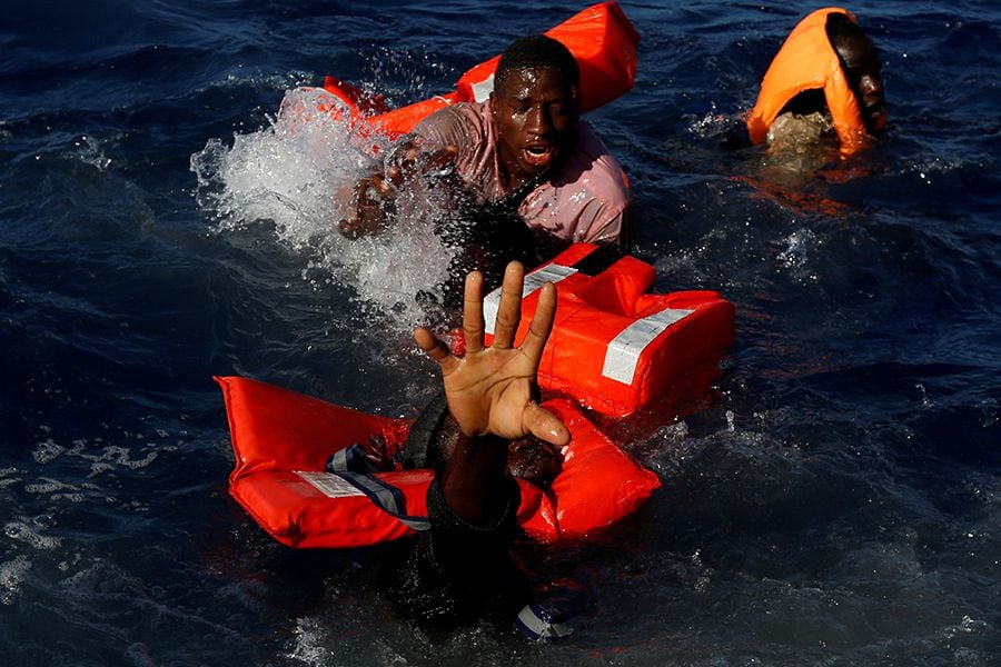 Migrantes tratan de salir a flote tras el naufragio de su embarcación en el Mediterráneo, cerca de Libia, en abril de 2017.