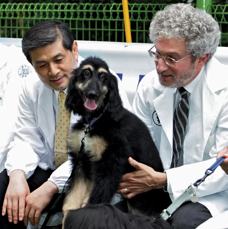 Hwang Woo-suk junto a Snuppy, el primer cachorro clonado de la historia. Fotografía de AP.