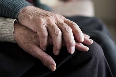 la foto muestra manos entrelazadas de adultos mayores