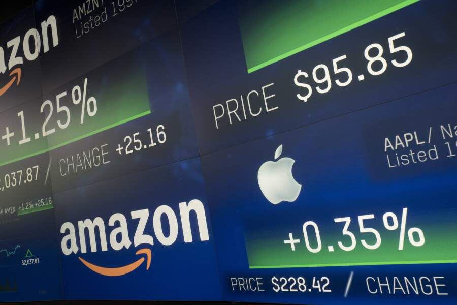 Amazon and Apple stock prices are shown on an electronic screen at th