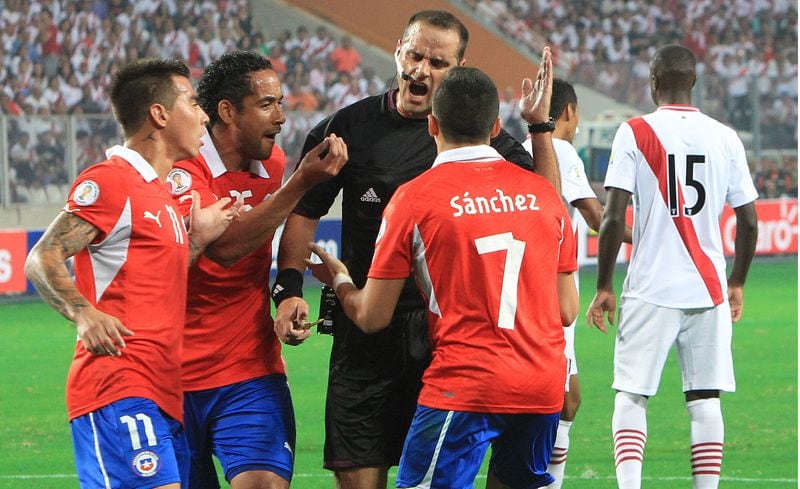 Eduardo Vargas, Jean Beausejour y Alexis Sánchez le reclaman al arbitro Diego Abal, durante el partido entre las selecciones de Peru y Chile, jugado en el Estadio Nacional de Lima en 2013.