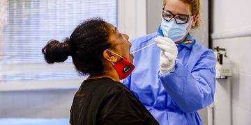 Una trabajadora sanitaria protegida realiza un test a una mujer.