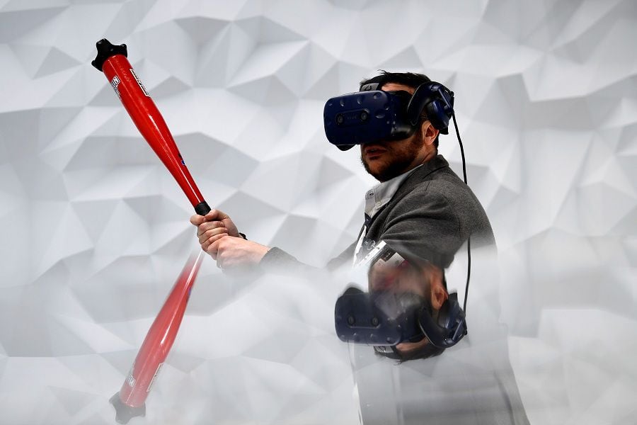 A visitor plays virtual baseball with the Vive Pro Eye virtual realit