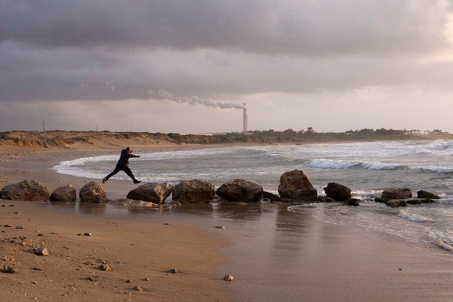 A man jumps between rocks at the beach on the Mediterranean Sea in Ca