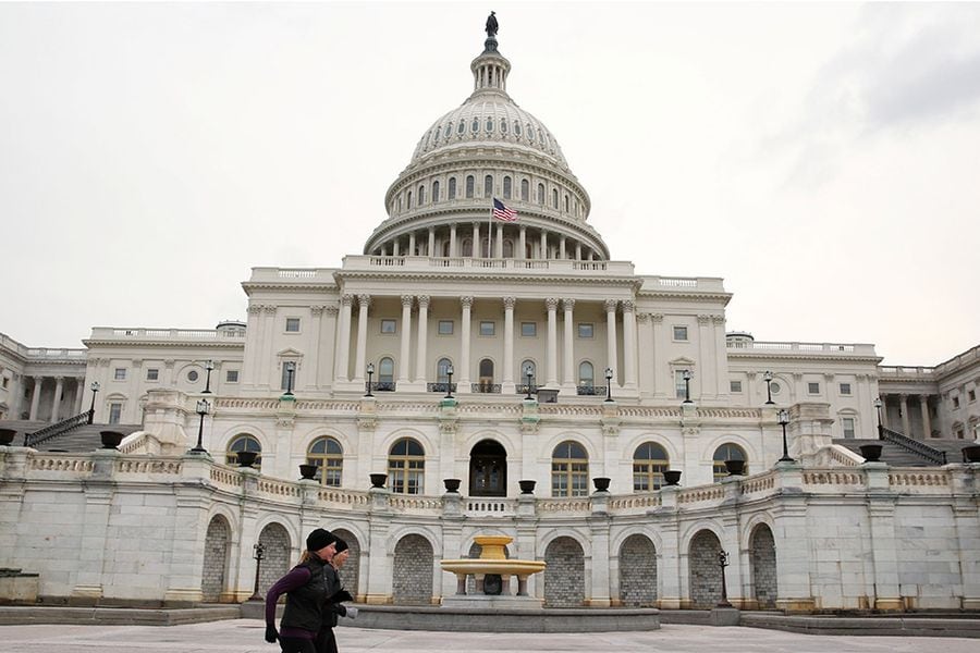 Runners stride past the U.S. Capitol building on the day of U.S. President Trump's State of the Union address to a joint session of the U.S. Congress at the Capitol in Washington