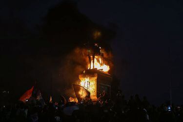 El momento de la quema del monumento de Baquedano.