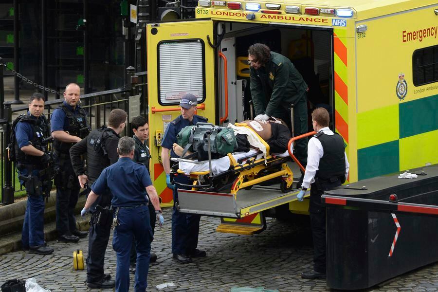 An attacker is treated by emergency services outside the Houses of Pa