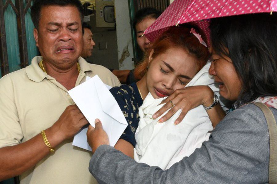 Jiranuch Trirat holds up the body of her 11-month-old daughter who was killed by her father, at a hospital in Phuket