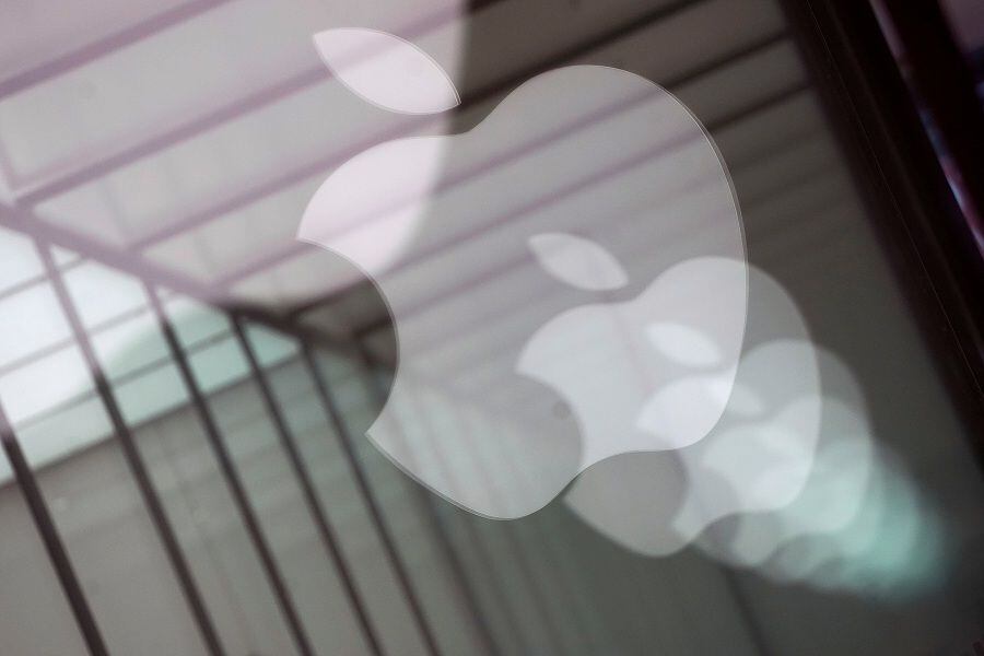 FILE PHOTO: Apple company logos are reflected on the glass window outside an Apple store in Shanghai