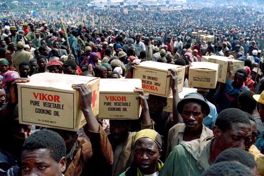 FILE PHOTO: Rwandan refugees carry food supplies away from a distribution point after the food was given out from the Red Cross