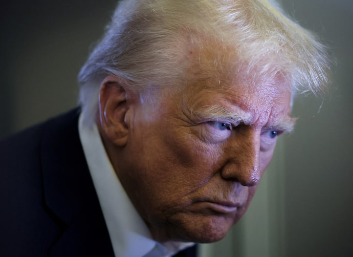 U.S. President Trump speaks to reporters aboard Air Force One on his way to Miami