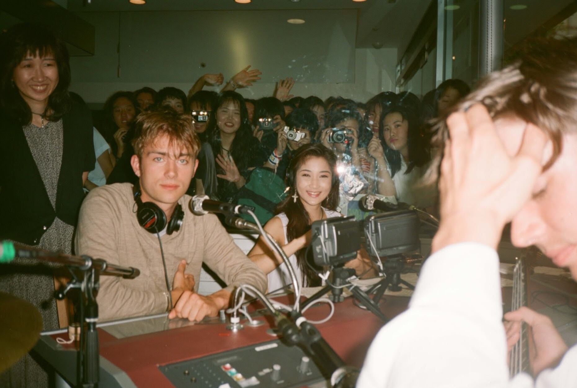 Damon Albarn mira fijo a la cámara, Álex James se toma la cabeza. Los días de locura de Blur en su primera visita a Japón. Una de las fotos de Dave Rowntree.