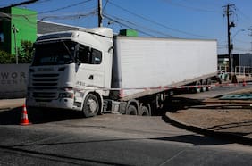 Camión con 20 toneladas de queso queda atrapado en calle de Renca tras caer a un socavón