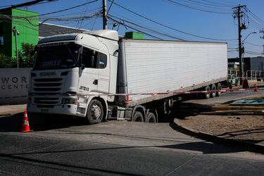 Camión con 20 toneladas de queso queda atrapado en calle de Renca tras caer a un socavón