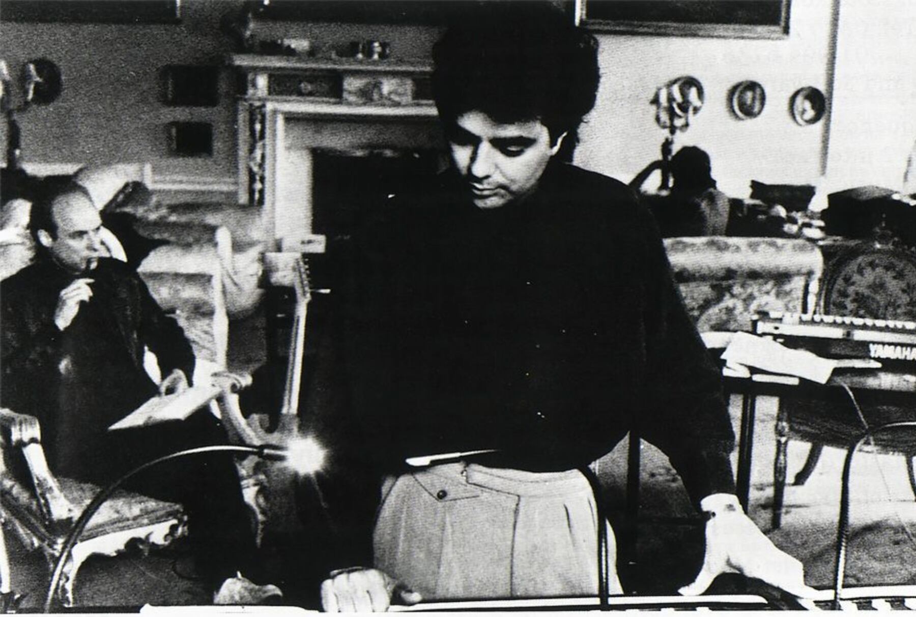 Daniel Lanois, trabajando en las sesiones de The Unforgettable Fire. Sentado, pensativo, está Brian Eno.