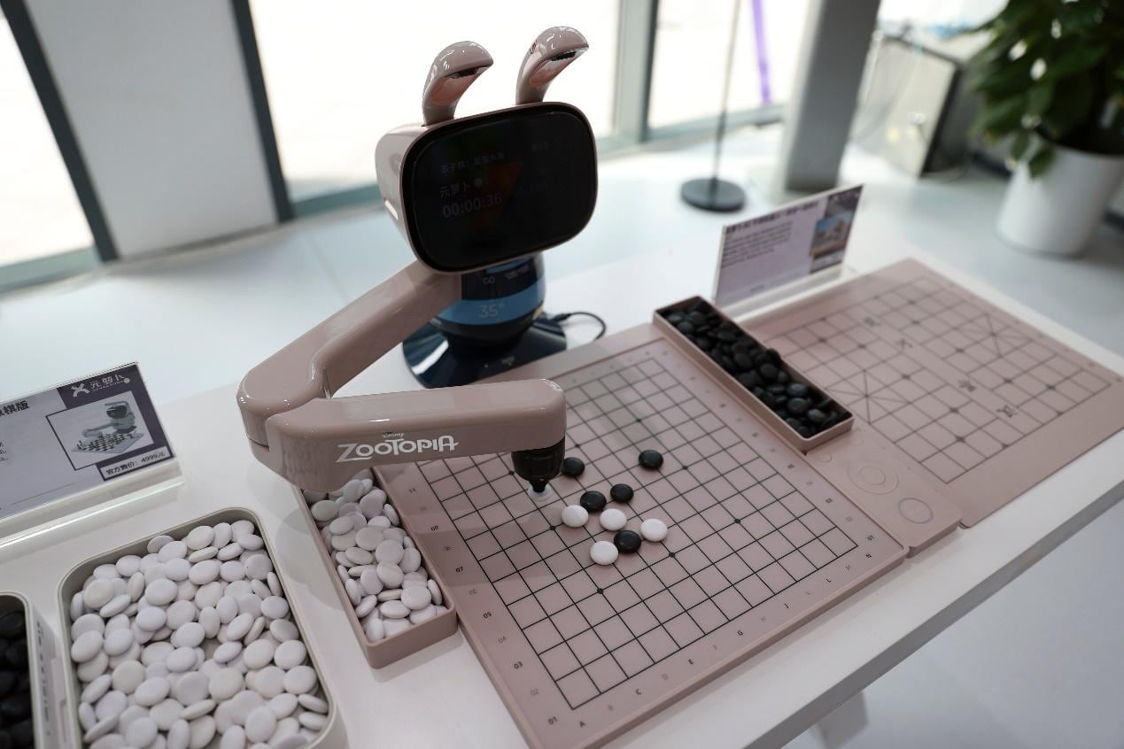 Robot impulsado por IA de SenseRobot juega una partida con un visitante en el E-Town de Beijing, capital de China, el 1 de julio de 2026. (Xinhua/Ma Zihan)
