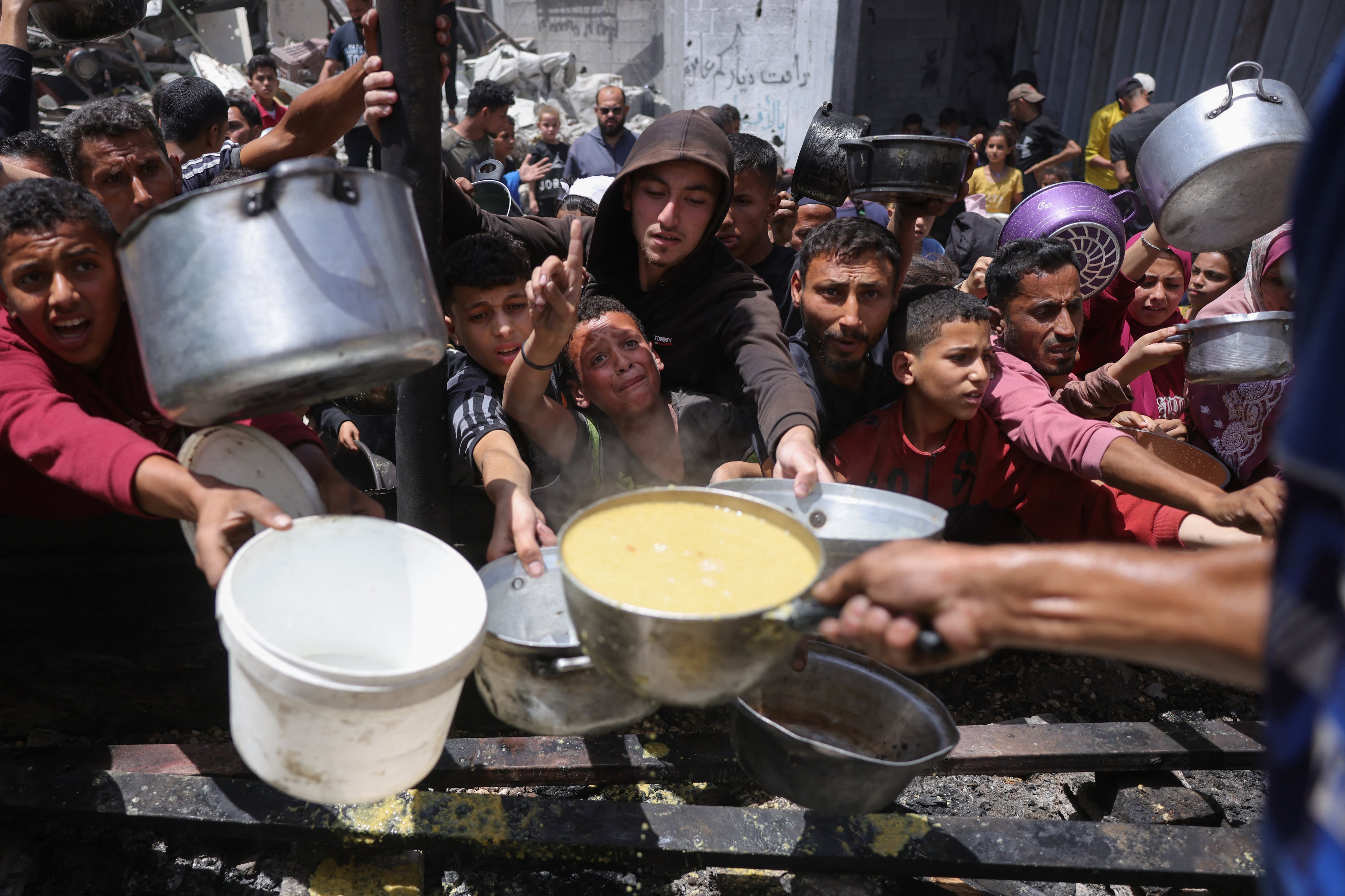 Palestinos desplazados se reúnen para recoger porciones de comida en un punto de distribución benéfica en Jabalia, al norte de la Franja de Gaza, el 19 de mayo de 2025. Foto: AFP