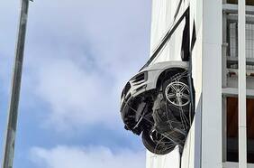 Increíble, pero cierto: un Porsche atraviesa la pared de un edificio y queda a punto de caer