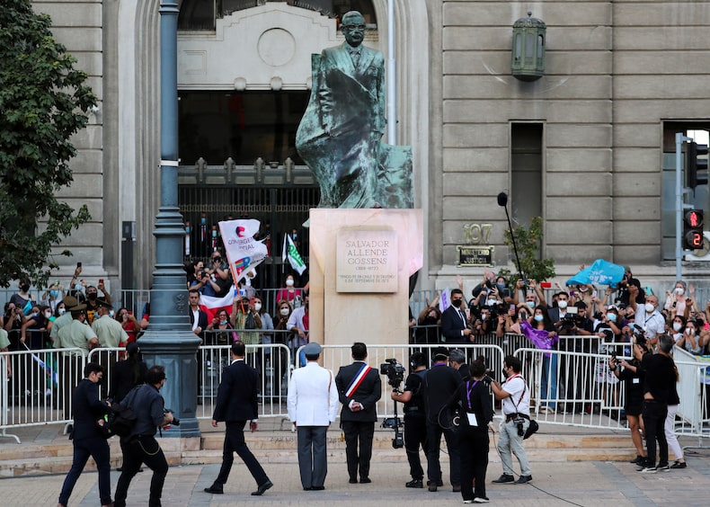 Chile's President Gabriel Boric stands in front of a monument of Chile's former president Salvador Allende in Santiago
