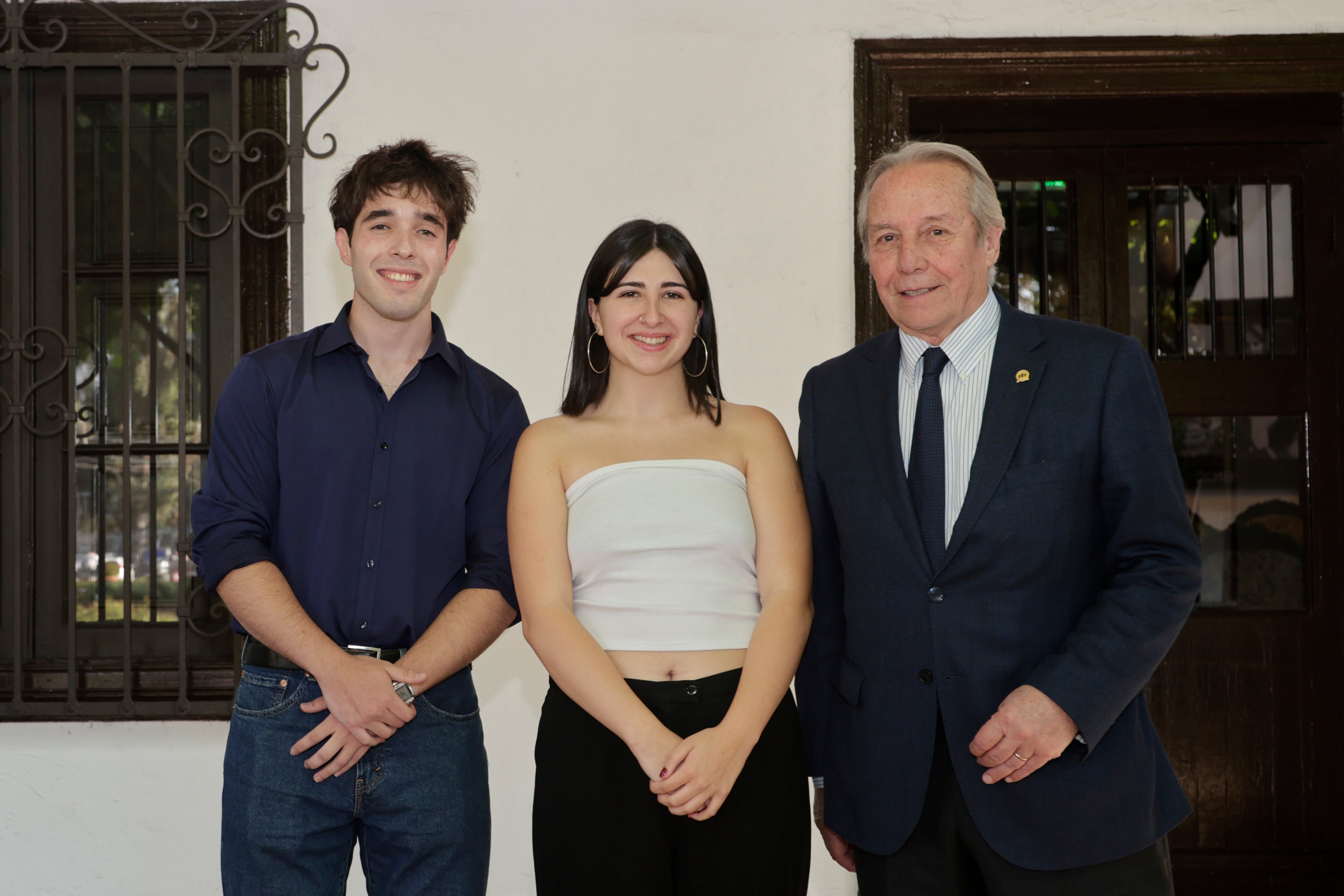 De Universidad Andrés Bello, Cristian Napoleoni e Ignacia Cartagena, estudiantes becados, junto al rector Julio Castro.