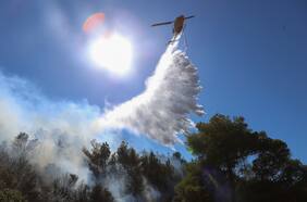 Bomberos griegos combaten un nuevo incendio forestal cerca de Atenas en medio de fuertes vientos