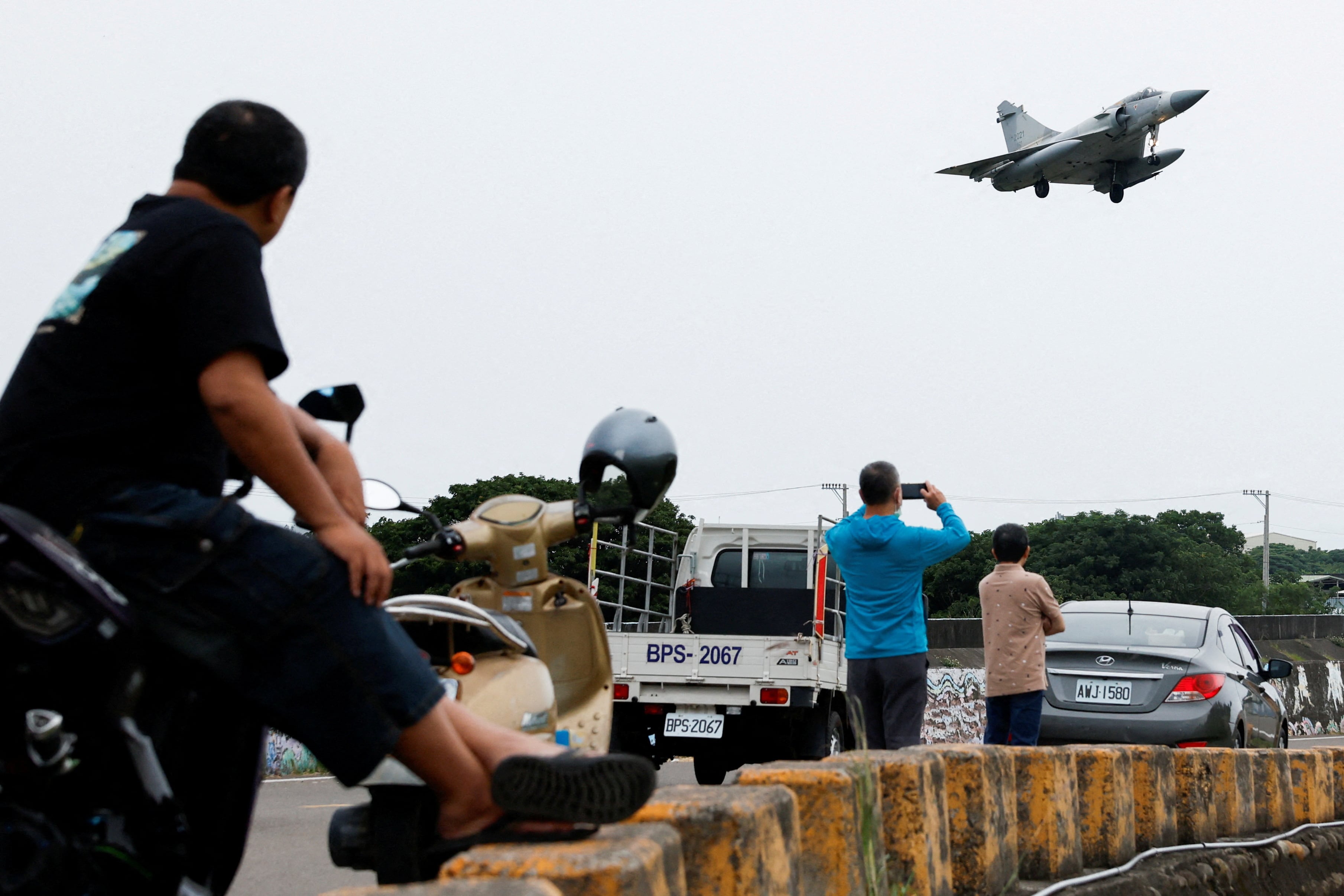 Personas observan un avión Mirage 2000-5 de la Fuerza Aérea de Taiwán mientras se prepara para aterrizar en la Base Aérea de Hsinchu, en Hsinchu, el 23 de mayo de 2024.