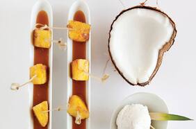 Brocheta de piña acaramelada, caramelo de coco y jengibre con helado de coco