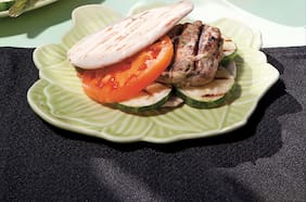 Hamburguesa de carne, zapallo italiano y hierbas sobre zapallo italiano grillado en pan pita