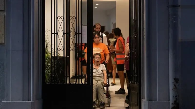 Maricarmen, saliendo de su vivienda en medio del desalojo en Madrid, España.