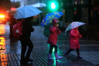 Personas caminando bajo la lluvia en Santiago