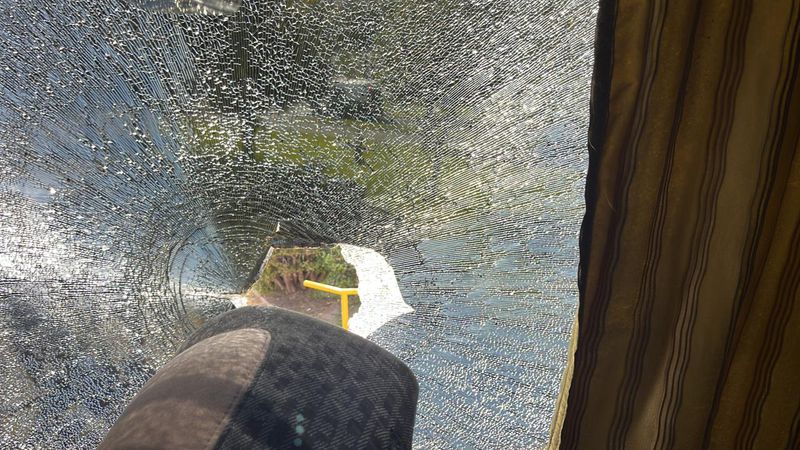 El interior del bus de la U con un vidrio quebrado.