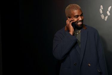 FILE PHOTO: Rapper Kanye West talks on the phone before attending the Versace presentation in New York