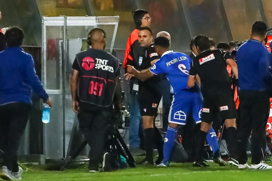 Piero Maza observa el VAR y Yonathan Andía, jugador de Universidad de Chile, va a reclamar.