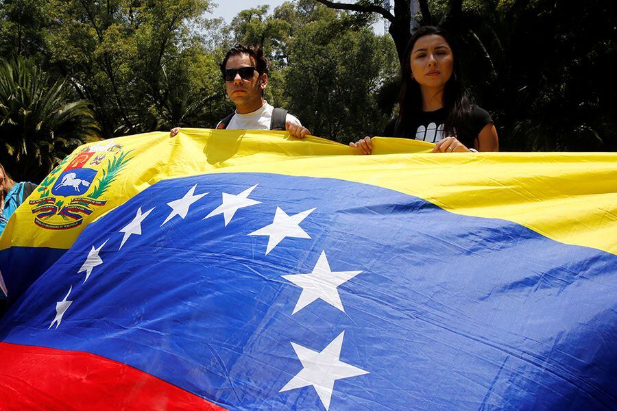 Franco Tintori holds a Venezuelan flag during a protest held by Venezuelans in Mexico against Venezuela's Constituent Assembly election, at the Heroic Children monument in Mexico City