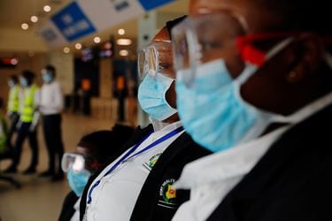 Health workers wait to screen travellers for signs of the coronavirus at the Kotoka International Airport in Accra