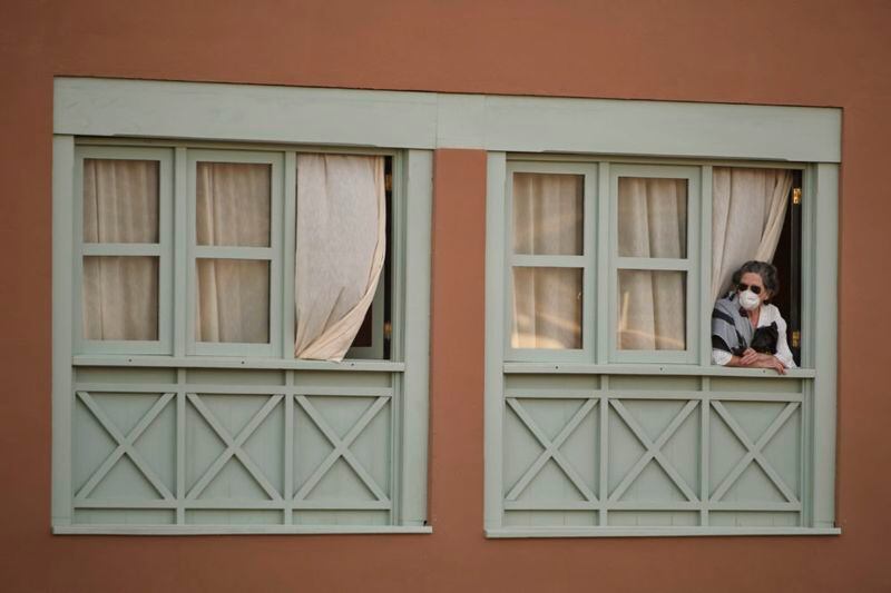 una mujer encerrada y mirando la ventana